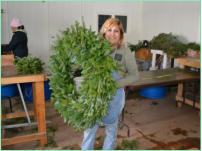 One of our wreath workers holding a 36" Fraser Fir Wreath